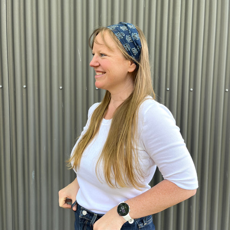 A woman smiling and wearing an indigo floral headband.